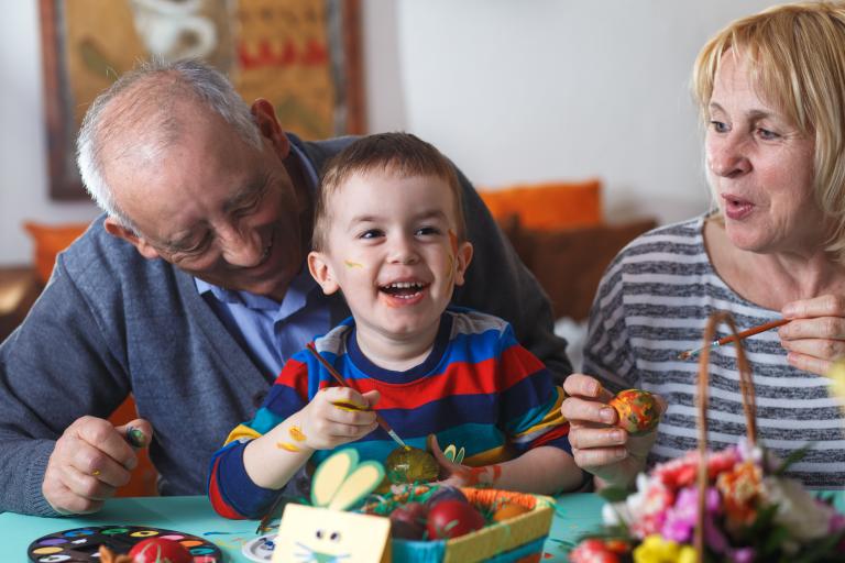 An older man and woman are sitting at a table with young child