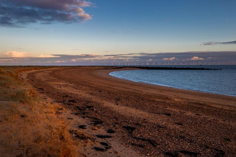 A wide angle shot of a beach at dusk.