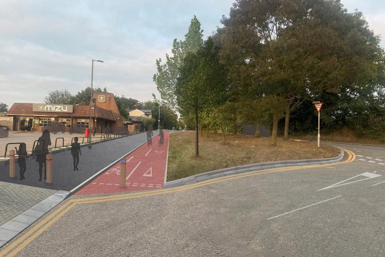 A street scene showing a red segregated cycle lane next to a pavement and a nearby restaurant.