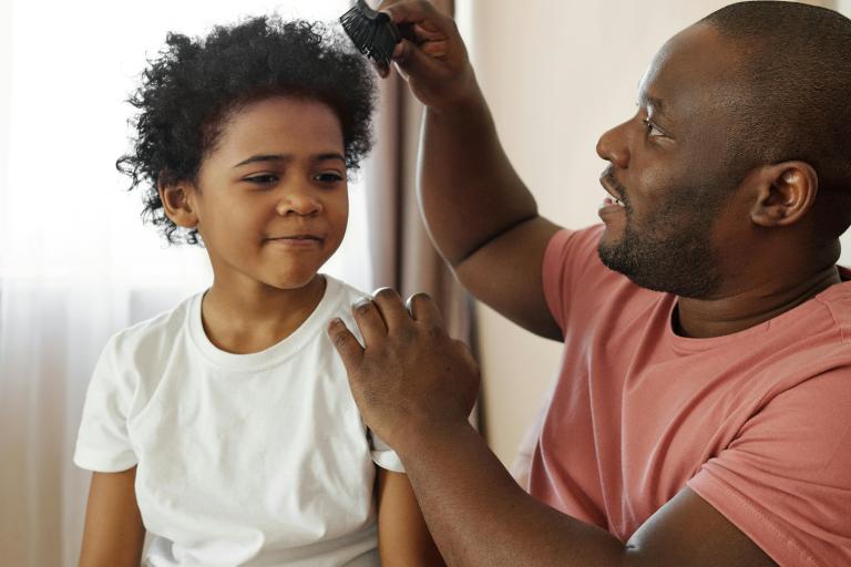 Man brushing a young boy's hair