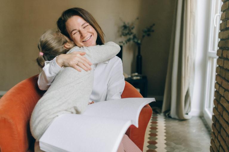 Woman getting a hug from a small girl