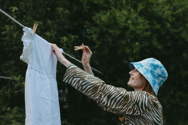 A teenage girl hanging her washing on the line outside