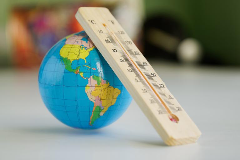 School ruler leaning against a globe on a desk in a classroom